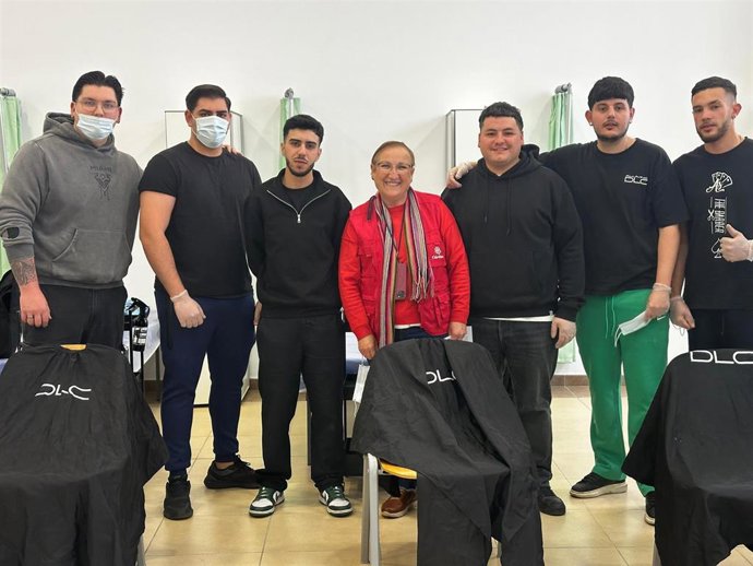 Voluntarios de la academia De La Calle Education, junto a la subdirectora de Cáritas Diocesana de Almería, Encarna Lacasa, durante una sesión del servicio de peluquería.