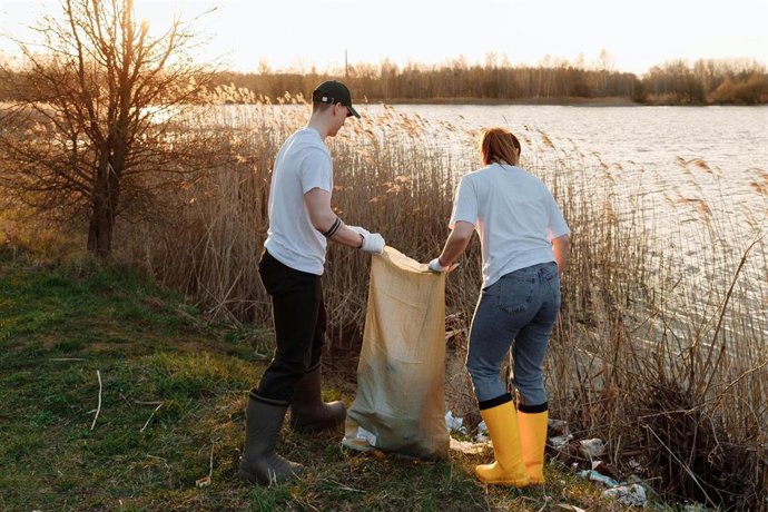 Imagen de personas limpiando la orilla de un río.