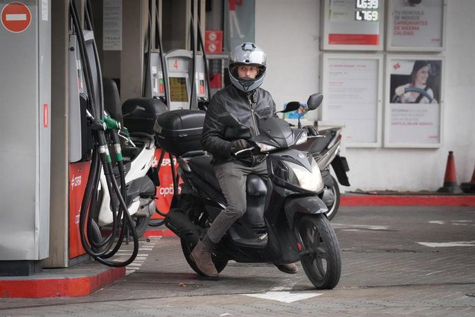 Una persona echa combustible a su moto en Barcelona.