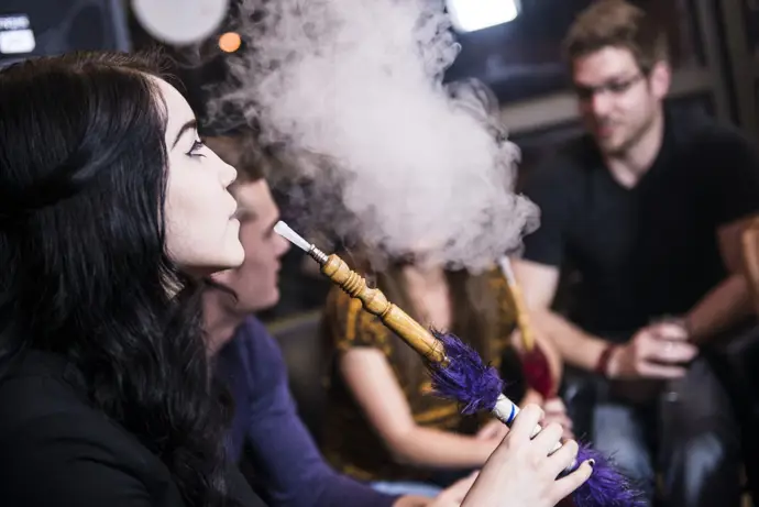 Jóvenes fumando en pipa de agua