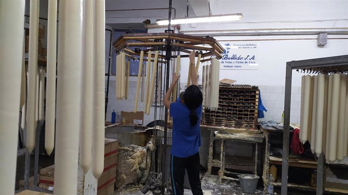 Archivo - Una trabajadora de Cera Bellido cuelga cirios.