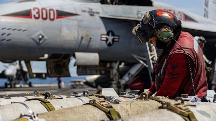 19 de março de 2026, local não revelado, águas internacionais: Um técnico de armamento da Marinha dos EUA prepara bombas para um caça F/A-18E Super Hornet do Esquadrão de Caças de Ataque 31 (Tomcatters), no convés de voo do porta-aviões da classe Ford USS