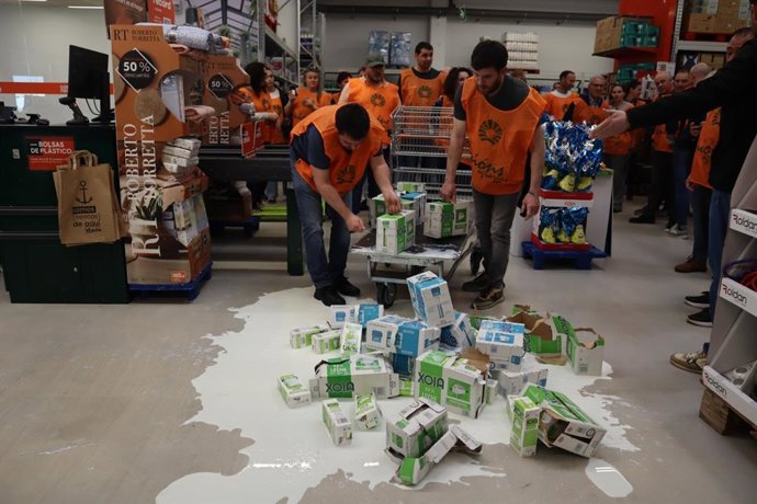 Varios miembros de Unións Agrarias derraman leche en el centro de Cash Galicia