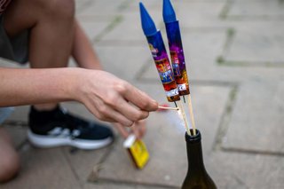 Archivo - Una persona enciende petardos durante la verbena de San Juan, a 23 de junio de 2024.