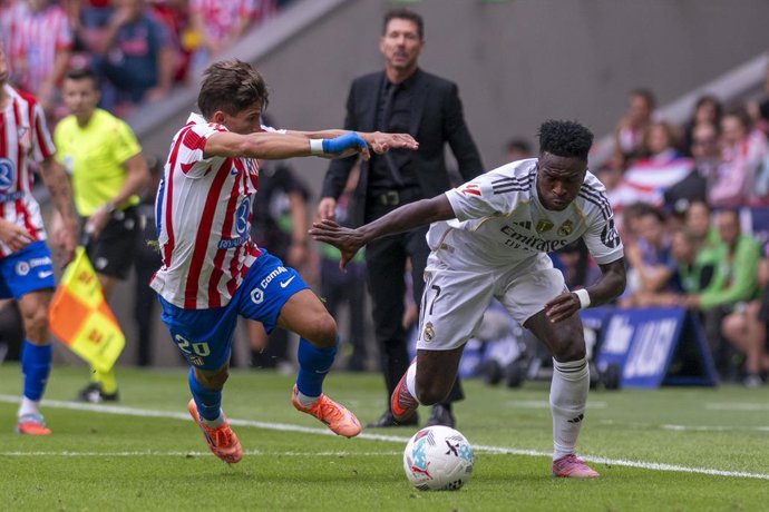 Archivo - 27 September 2025, Spain, Madrid: Real Madrid's Vinicius Junior and Atletico de Madrid's Giuliano Simeone battle for the ball during the Spanish Primera Division soccer match between Atletico de Madrid and Real Madrid at Estadio Riyadh Air Metro
