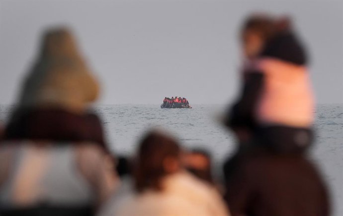 Archivo - Arquivo - 31 de maio de 2025, França, Gravelines: Um grupo de pessoas, supostamente migrantes, espera no mar para embarcar em uma pequena embarcação que parte da praia de Gravelines, na França, na tentativa de chegar ao Reino Unido atravessando 