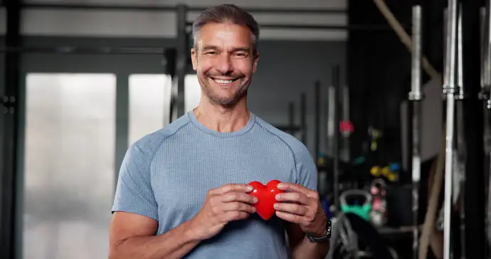 Hombre en un gimnasio sosteniendo un corazón