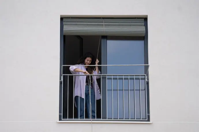 Inquilina cerrando la persiana de su piso en Barcelona