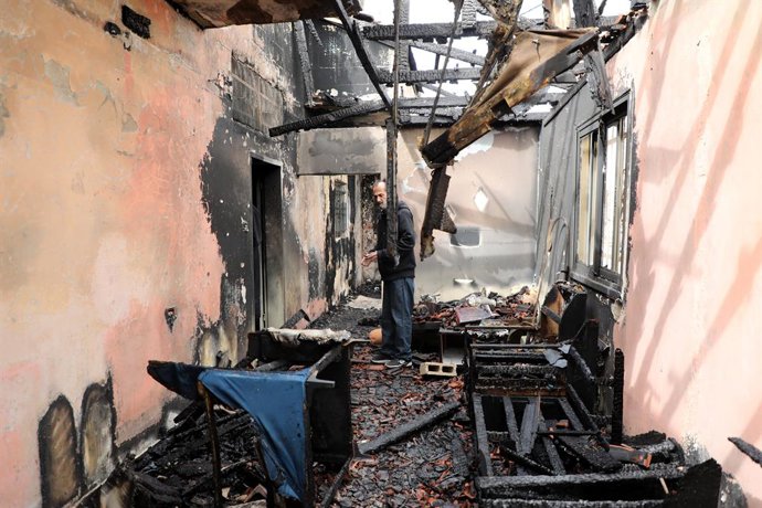 22 de março de 2026, Jenin, Cisjordânia, Palestina: Um palestino revisa seus pertences após um ataque de colonos judeus a uma propriedade agrícola na aldeia de Funduqmiya. O ataque ocorreu após o assassinato de um pastor judeu do assentamento de Elon M