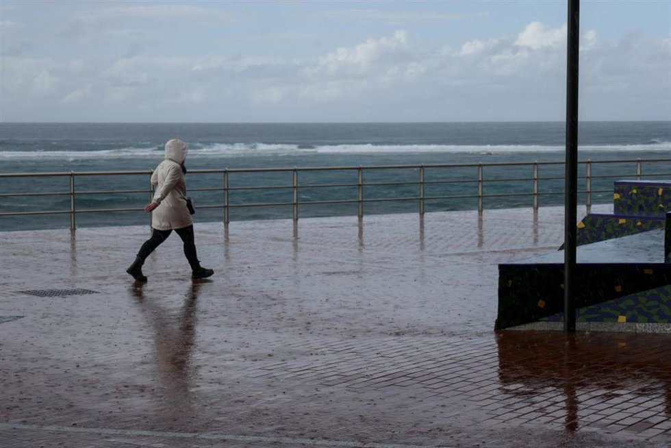 Archivo - Un hombre camina bajo la lluvia en Las Palmas de Gran Canaria, en Canarias (España)