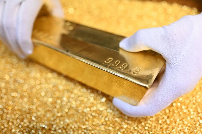 Archivo - FILED - 20 March 2023, Pforzheim: A gold bar weighing 12.5 kilograms is placed on gold granules at Agosi AG in Pforzheim. Photo: Uli Deck/dpa