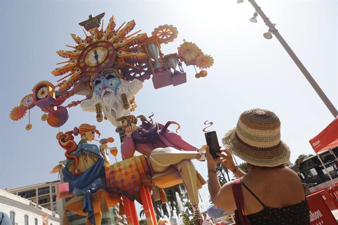 Archivo - Una mujer toma una fotografía de un monumento de las Hogueras de San Juan en la ciudad de Alicante