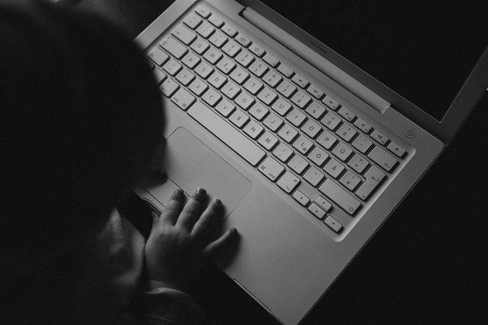 Ordenador portátil con la mano de un niño.