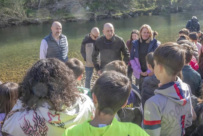 La consejera de Pesca, María Jesús Susinos, participa en la suelta de alevines de trucha en el río Pas junto a alumnos del colegio Cuevas del Castillo de Vargas