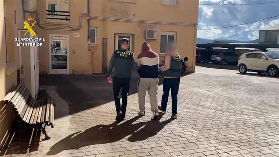 Archivo - Dos agentes de la Guardia Civil acompañan a uno de los detenidos de una operación que ha permitido destapar cerca de 24 kilómetros de cable de cobre de las obras de la A-30