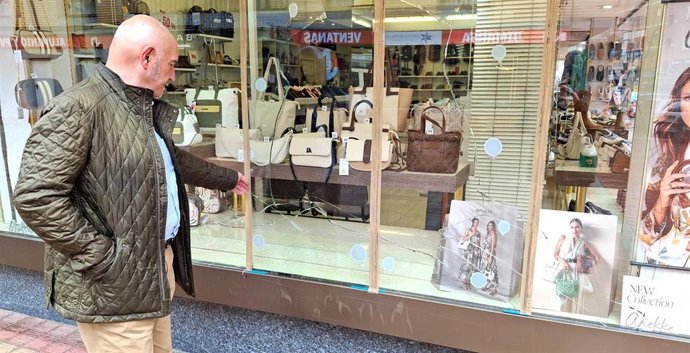 El concejal Ángel Madrazo ante el escaparate roto de un comercio asaltado