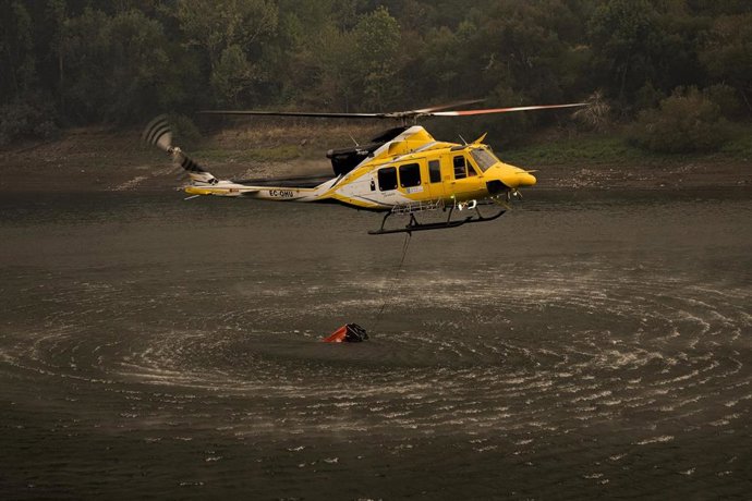 Archivo - Un helicóptero recoge agua para ayudar con las labores de extinción del incendio, a 26 de agosto de 2025, en Aguas Mestas, Lugo, Galicia (España). 