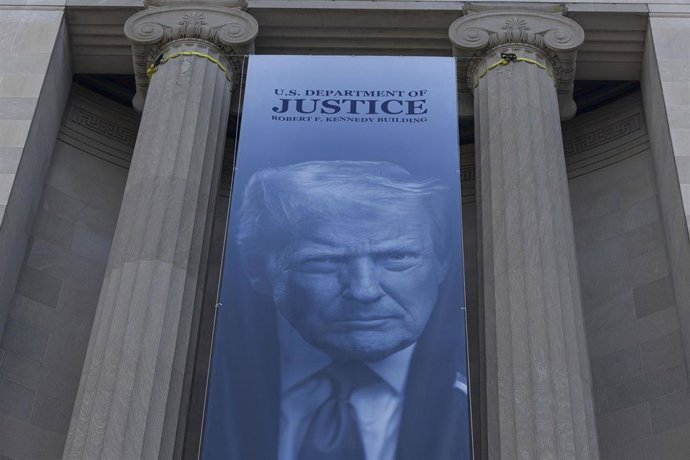 Archivo - Una gran pancarta con la imagen del presidente de Estados Unidos, Donald Trump, y el lema "Hagamos que Estados Unidos vuelva a ser seguro" se exhibe en el exterior de la sede del Departamento de Justicia