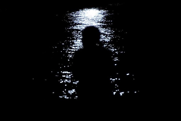 Una persona sentada frente al mar en La Habana durante un apagón en la isla. Imagen de archivo