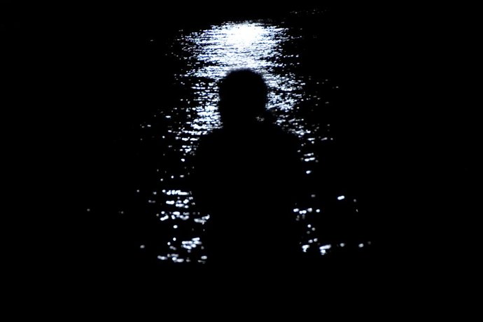 HAVANA, March 23, 2026  -- A person sits on a seawall during a blackout in Havana, Cuba, on March 21, 2026.   Cuba's national electric system has been restored following a total blackout on Saturday due to a major power grid failure. This blackout marked 