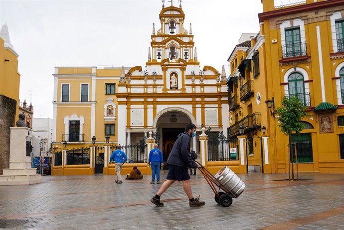Archivo - Un repartidor de barriles de cervezas pasa por la Plaza de la  Macarena, en foto de archivo.