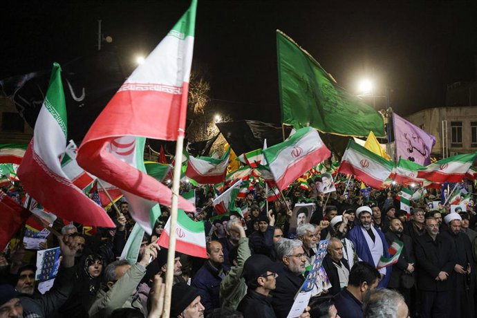 24 de março de 2026, Irã, Irã: Manifestantes pró-governo iranianos agitam bandeiras nacionais durante uma manifestação. O Irã afirmou ter disparado mísseis de cruzeiro contra o porta-aviões USS Abraham Lincoln, de acordo com um comunicado divulgado pela t