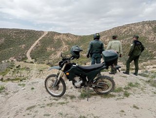 Agentes del Seprona y Medio Ambiente, junto a una motocicleta, durante una labor de vigilancia en una zona de monte de Almería.