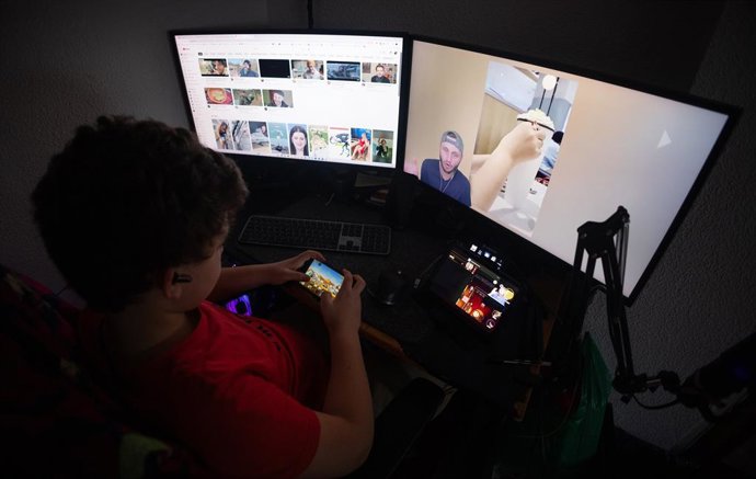 Archivo - Un niño mientras observa varias pantallas, a 20 de enero de 2025, en Madrid (España).