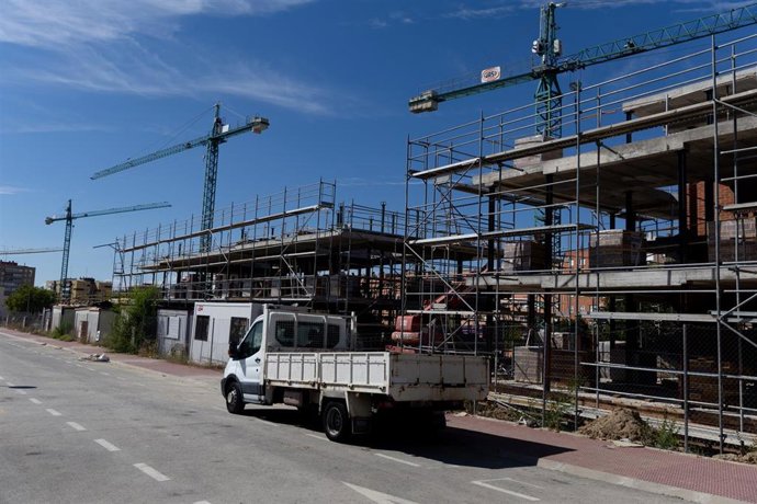 Archivo - Un camión delante de las obras de vivienda nueva.