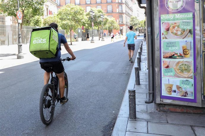 Archivo - Un repartidor de la empresa Uber Eats en bicicleta por una calle del centro de Madrid