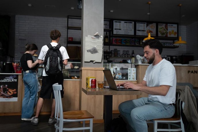 Archivo - Varios clientes esperan en el interior de un bar