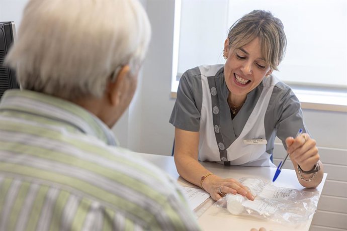 Enfermera recibe a paciente en consulta.
