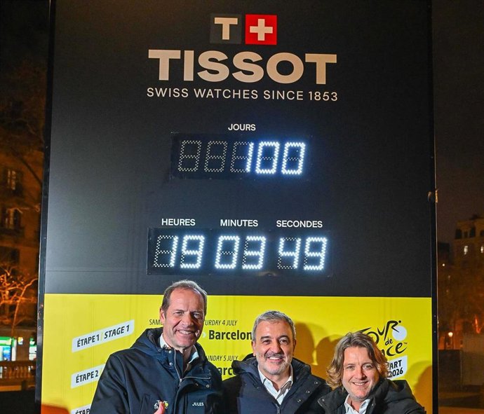 De izquierda a derecha, Christian Prudhomme, director del Tour de France; Jaume Collboni, alcalde de Barcelona; y David Escudé, concejal de deportes de Barcelona, posando en frente del reloj Tissot que puso en marcha la cuenta atrás para el Grand Départ
