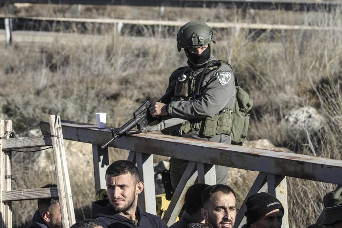 Archivo - Arquivo - 27 de novembro de 2024, Nablus, Cisjordânia, Palestina: Soldados israelenses vigiam o portão enquanto agricultores palestinos aguardam que o exército de ocupação israelense abra o portão do assentamento israelense de Elon Moreh para qu