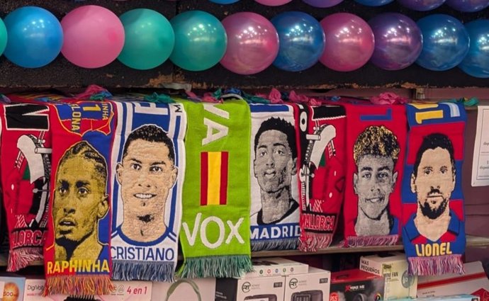 Polémica en la Fira del Ram: MÉS denuncia la venta de bufandas de Vox y exige responsabilidades al Ayuntamiento Bufandas expuestas en la Fira del Ram.