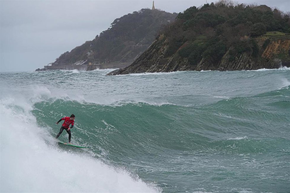 Archivo - Una persona hace surf en la playa de Ondarreta