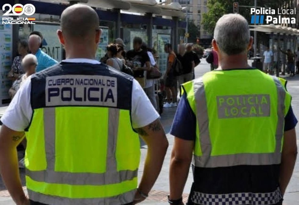 Un agente de la Policía Nacional y otro de la Policía Local de Palma, de espaldas.