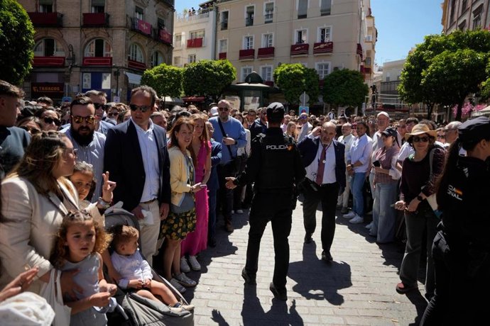 Un policía habla con un miembro de la Hermandad del Amor tras el incendio de la calle Cuna