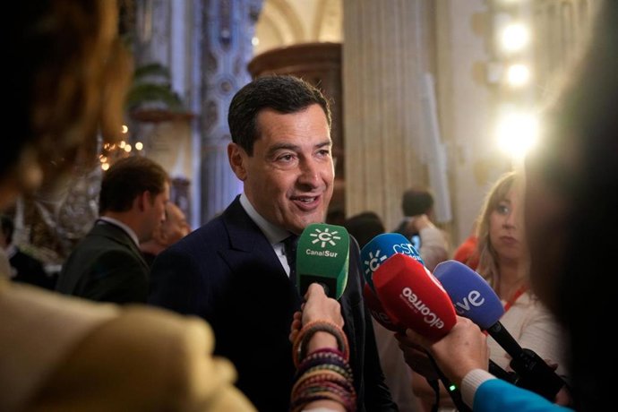 O presidente da Junta da Andaluzia, Juanma Moreno, fala com a imprensa antes da saída da La Borriquita da igreja de El Salvador, em Sevilha.