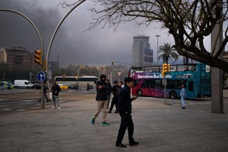 Diverses persones entre la fumera provocada per l'incendi