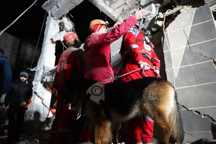 25 de março de 2026, Irã, Irã: Equipes de resgate da Sociedade do Crescente Vermelho Iraniano (IRCS) estão trabalhando no local de um prédio destruído por um ataque aéreo. O Irã afirmou ter disparado mísseis de cruzeiro contra o porta-aviões USS Abraham L
