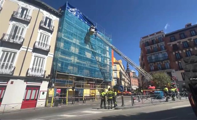 Los bomberos de Madrid proceden al desmontaje de un andamio en la calle Toledo, que se había desprendido a causa del viento.