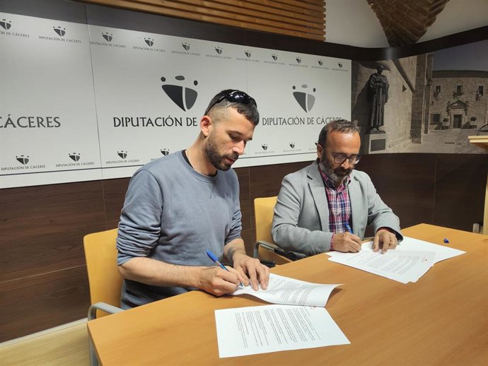 Sergio Gómez, conocido artísticamente como El Gato con Jotas, y el presidente de la Diputación de Cáceres, Miguel Ángel Morales, firman un convenio de colaboración