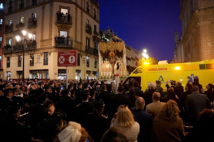 Una ambulancia recorre la avenida de la Constitución al paso de la Virgen de Gracia y Esperanza de Sevilla