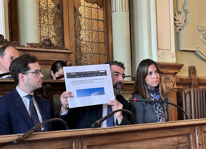 El concejal Alberto Gutiérrez Alberca (en el centro) muestra una información en prensa sobre la reclamación de los trabajadores de Auvasa al anterior equipo de Gobierno.