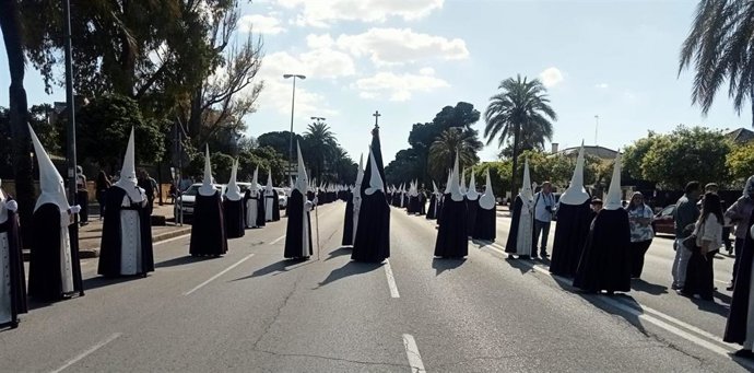 Nazarenos de la Hermandad de La Entrega buscando el centro de Jerez por la Avenida Domecq a las cuatro de la tarde del Sábado de Pasión.
