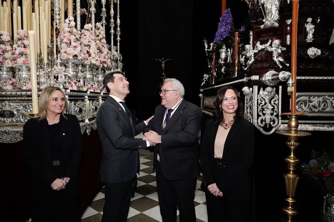 El presidente de la Junta de Andalucía, Juanma Moreno (2i), recibe la insignia de la Hermandad del Santísimo Cristo de San Agustín, una de las cofradías más esperadas del Lunes Santo Granadino. A 30 de marzo de 2026 en Granada (Andalucía, España). 