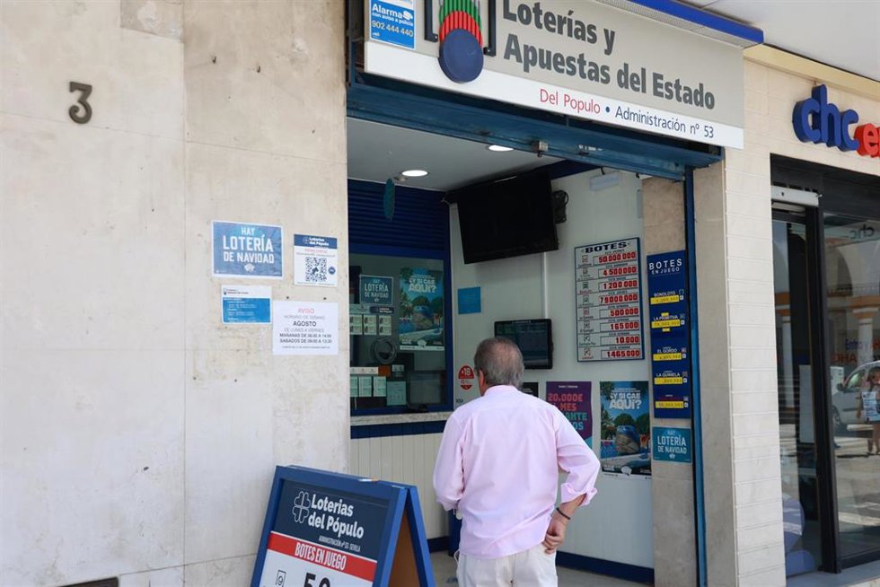 Archivo - Una persona se dispone a adquierir un boleto en una Administración de Loterias.