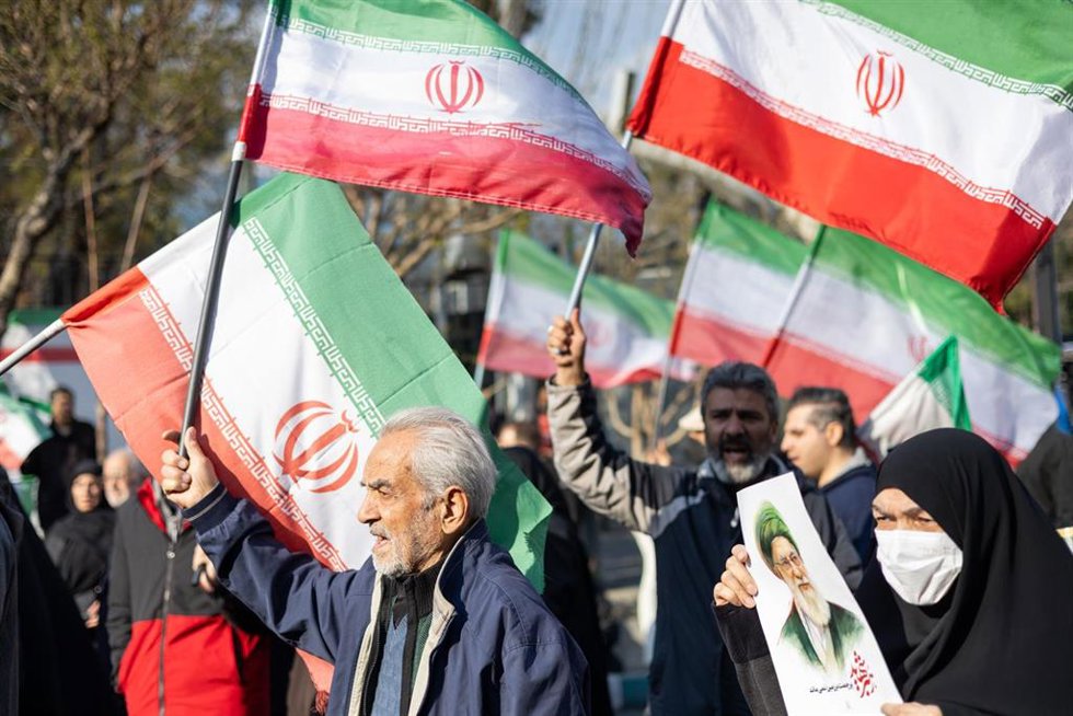 Un hombre sostiene la bandera iraní tras el anuncio del nombramiento del líder supremo, Mojtaba Jamenei. 