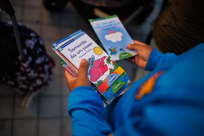 Archivo - Un niño mira los libros que ha cogido del puesto de regalos durante la entrega regalos a más100 niños vulnerables, a 4 de enero de 2023, en Madrid (España). La Fundación Madrina reparte regalos hasta mañana jueves 5 de enero entre los niños más 